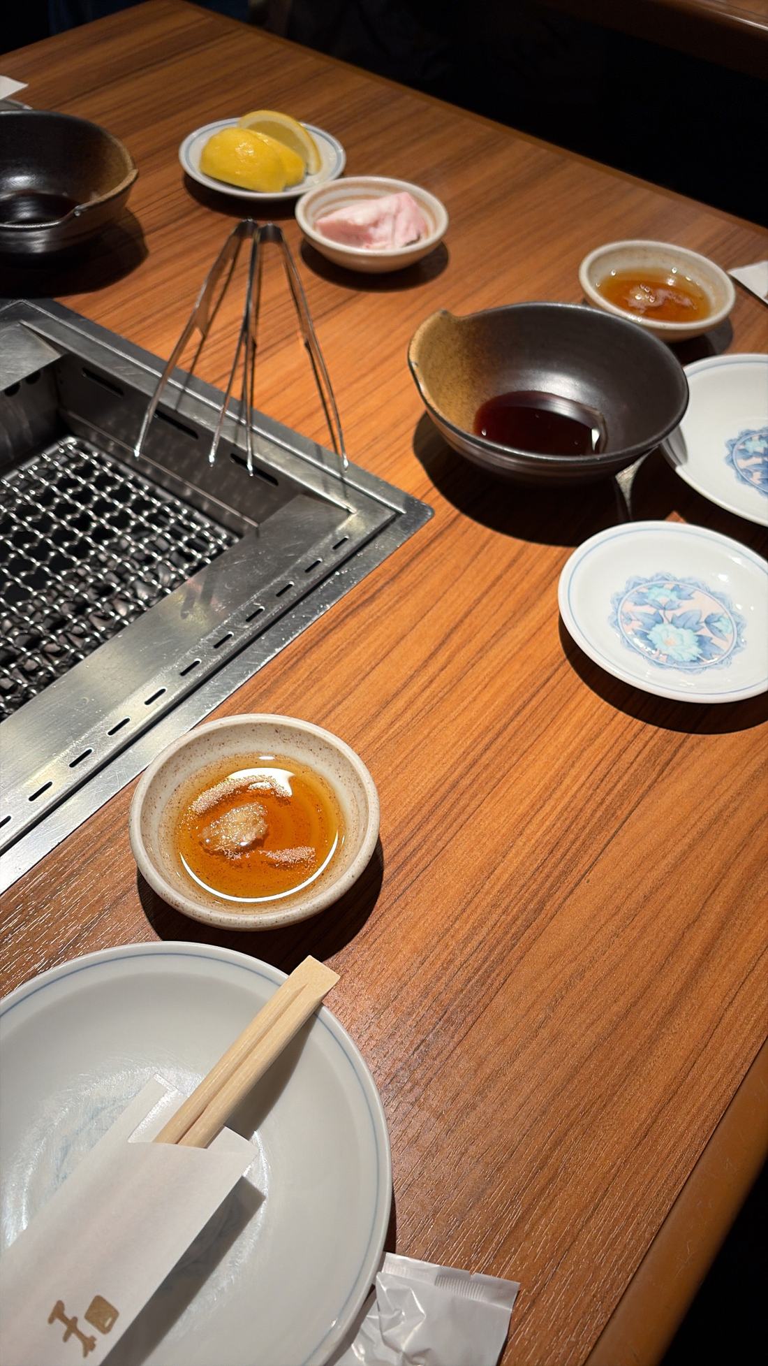 焼く前の卓上。網とタレと小皿が並んでいる